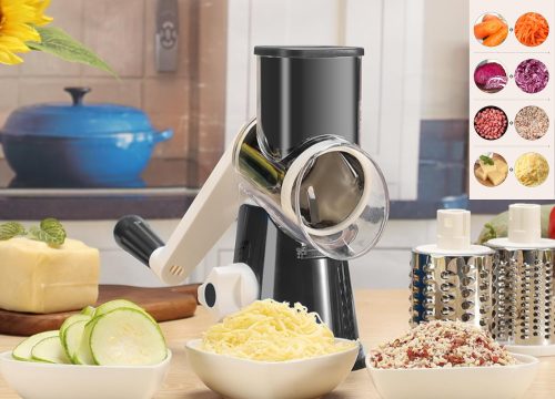 The image shows a Cambom Rotary Cheese Grater, a black and silver kitchen tool with a clear chamber, positioned on a wooden surface with grated cheese and sliced zucchini. A blue pot is visible in the background, and a chart on the right displays various grated vegetables.