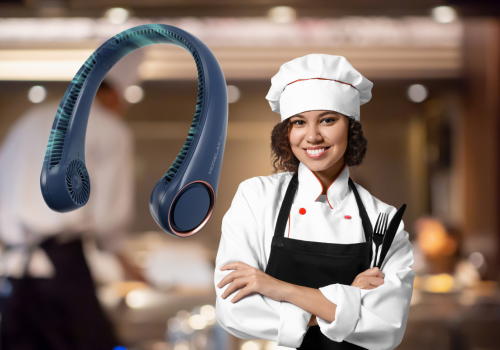 A dark blue portable neck fan is positioned on the left side of the image. On the right, a smiling individual, who appears to be female, is dressed in a white chef's coat, a black apron, and a tall white chef's hat. They have their arms crossed and are holding a knife and fork. The background is blurred, suggesting a kitchen or dining environment with warm lighting.